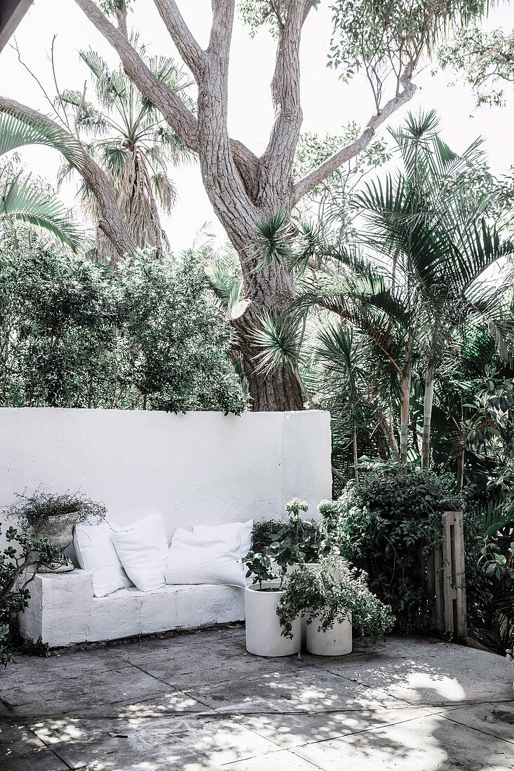 White dividing wall with integrated bench on summer terrace