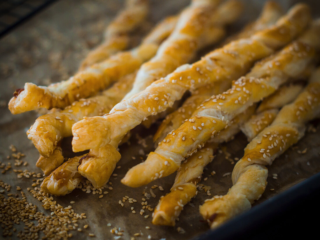 Pastry sticks with bacon and sesame seeds