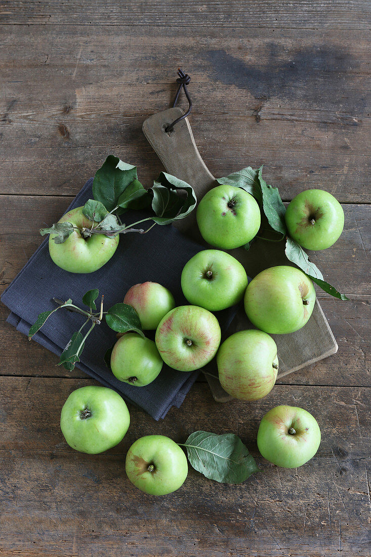An arrangement of green organic apples on a rustic wooden table