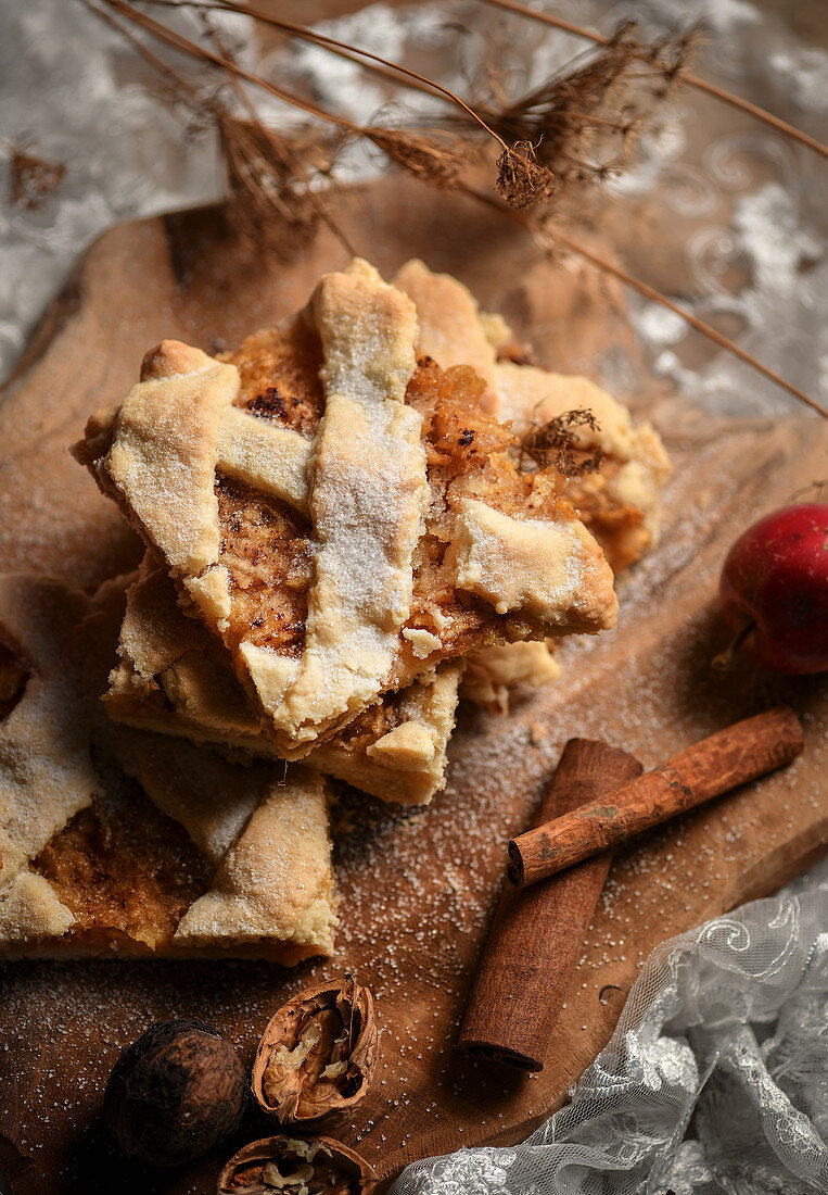 Mehrere Stücke Apfelkuchen vom Blech mit Zimt und Nüssen