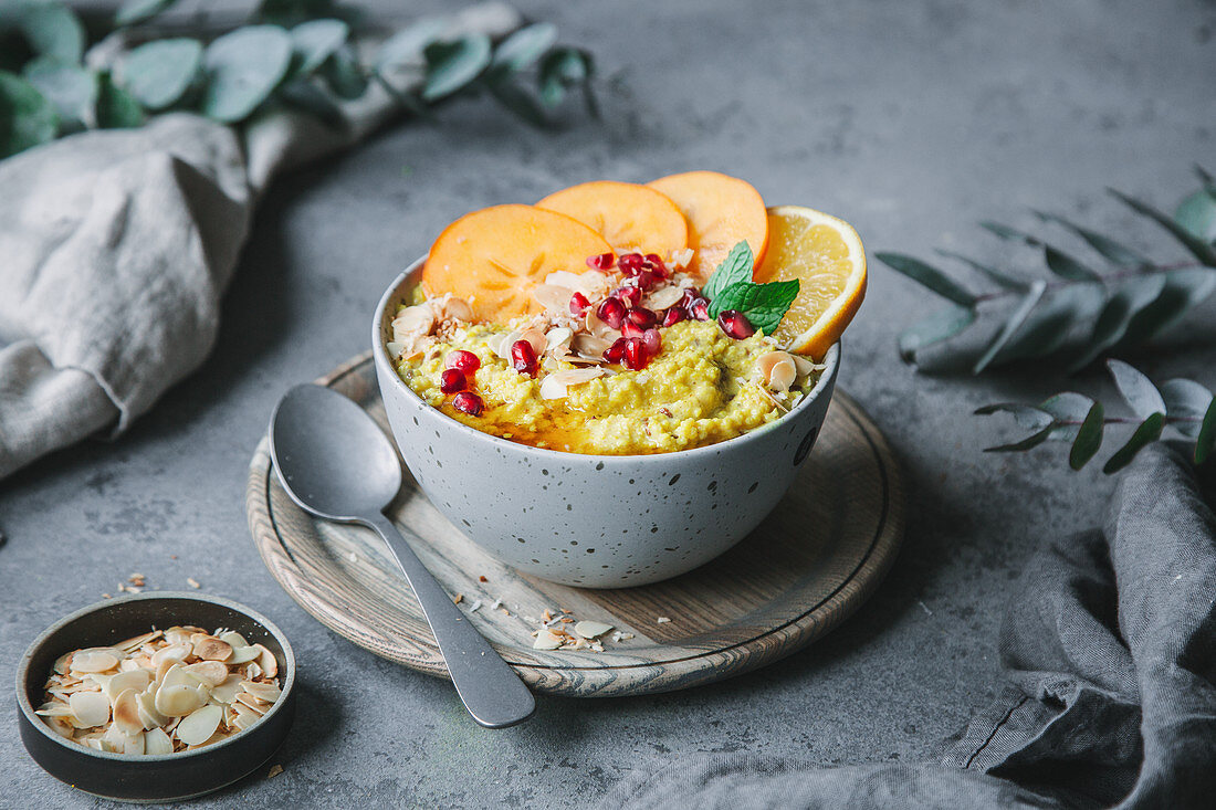 Kurkuma-Hirseporridge mit Kaki, Orangen und Granatapfelkernen