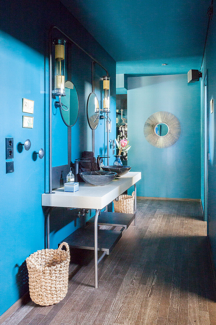 Washstand with twin sinks against blue wall in hall