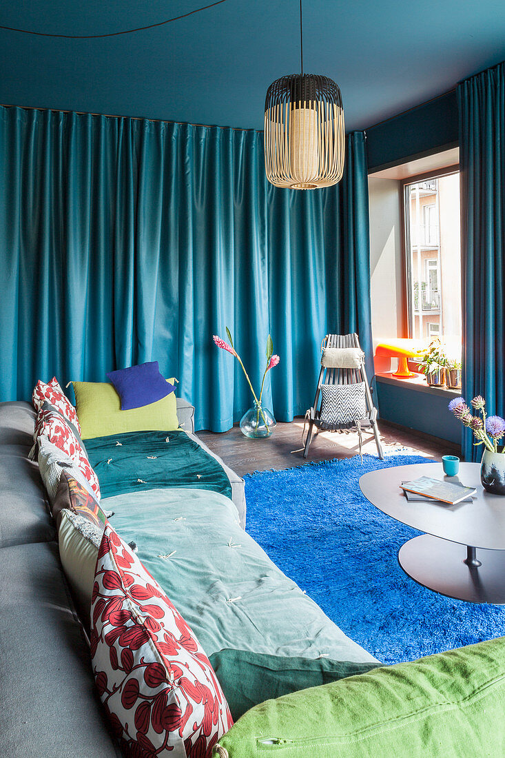 Wohnzimmer in kräftigen Blautönen mit farbiger Decke