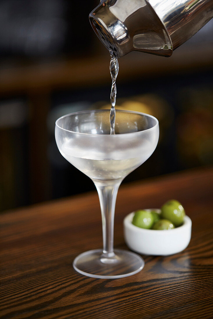 Martini aus Shaker in Glas gießen