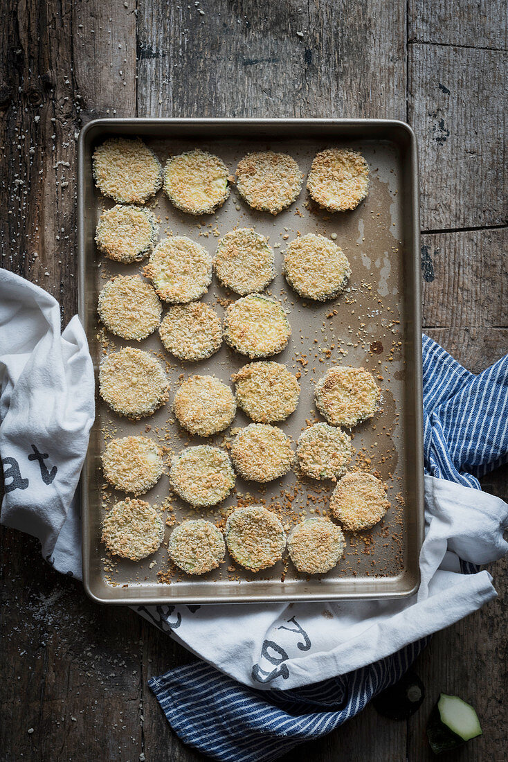 From above shot of zucchini slices in panko crumbs arranged on sheet pan