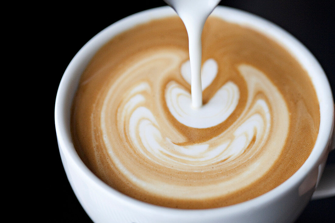 Kaffee mit kunstvollem Milchschaum-Muster