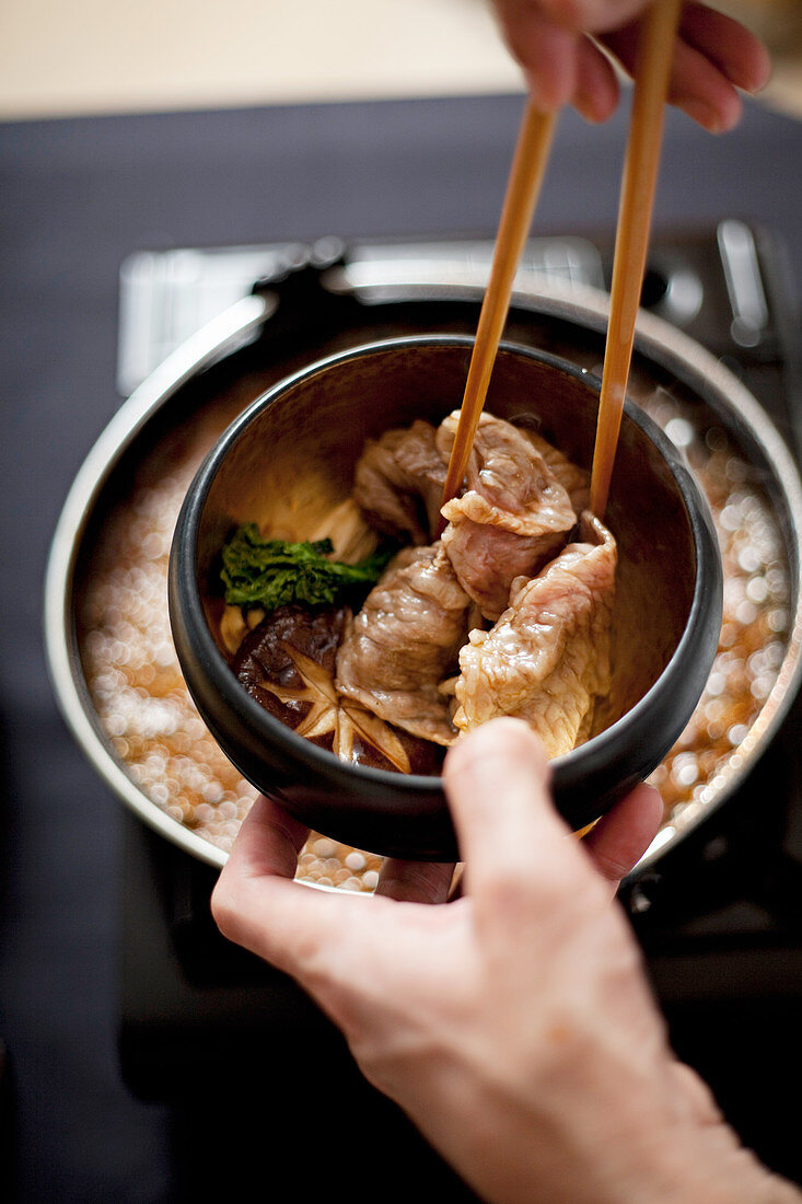 Wagu beef being eaten with chopsticks