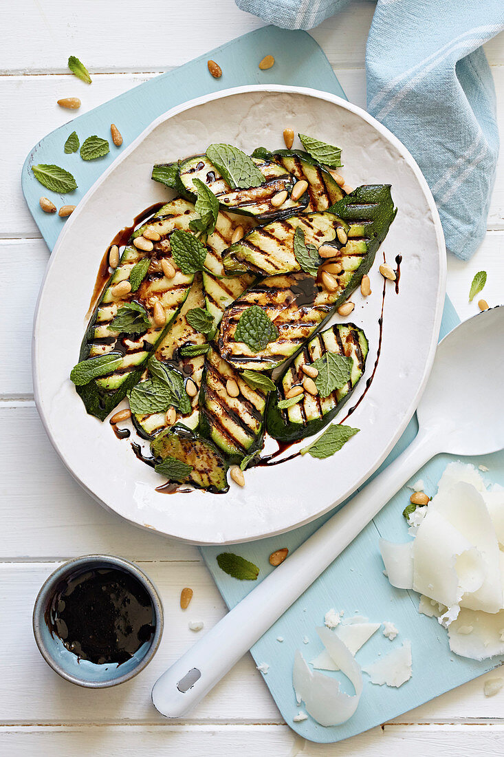 Grilled courgettes covered with herbs and pine nuts