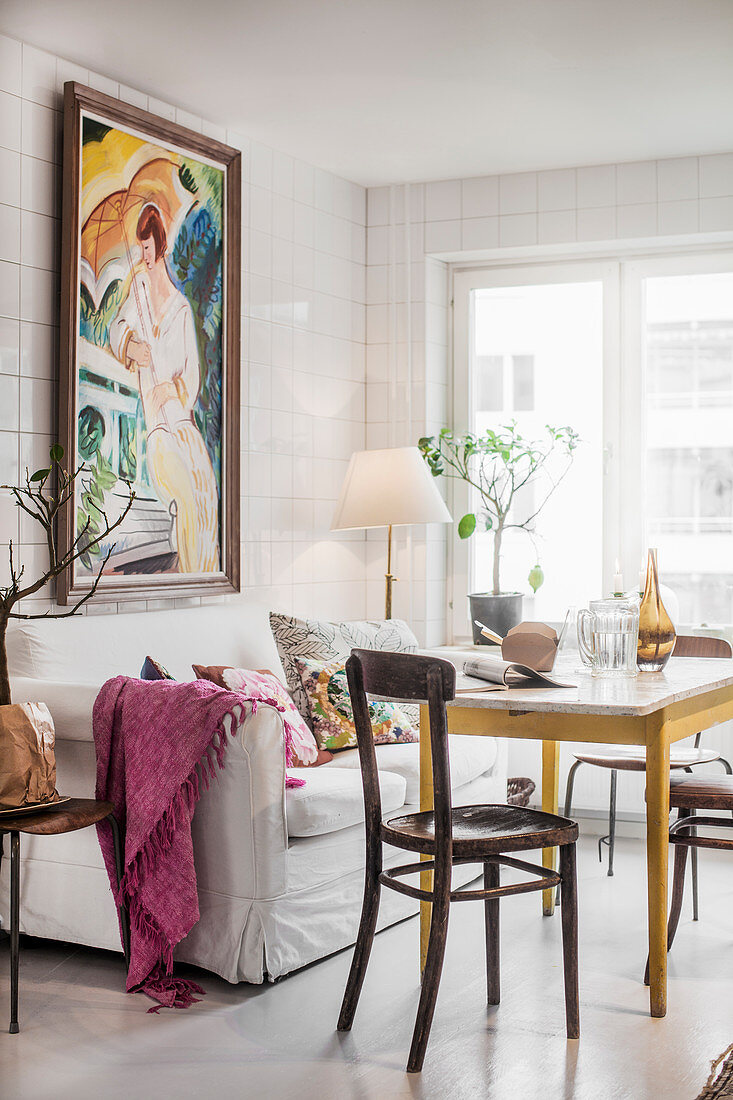 Gemütlicher Essplatz mit Sofa und Gemälde in gefliester Küche