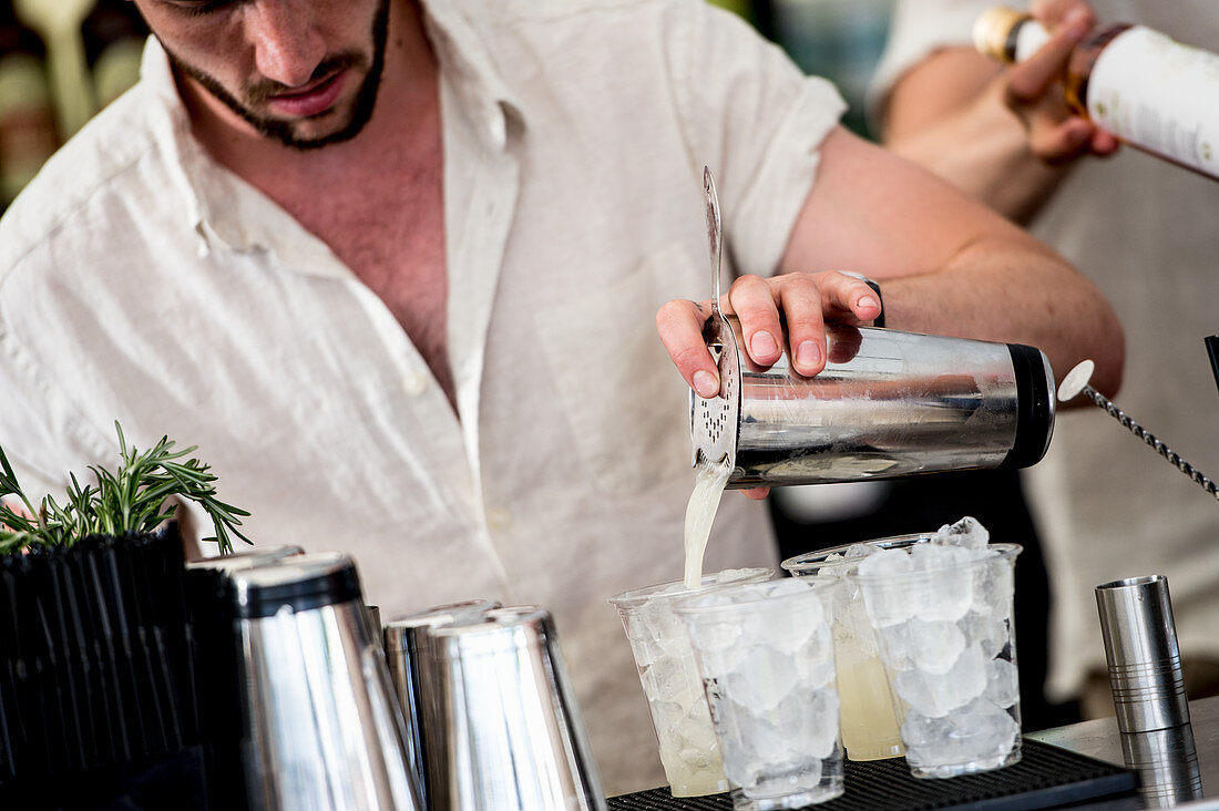 Barkeeper bereitet Cocktails mit Eiswürfeln zu