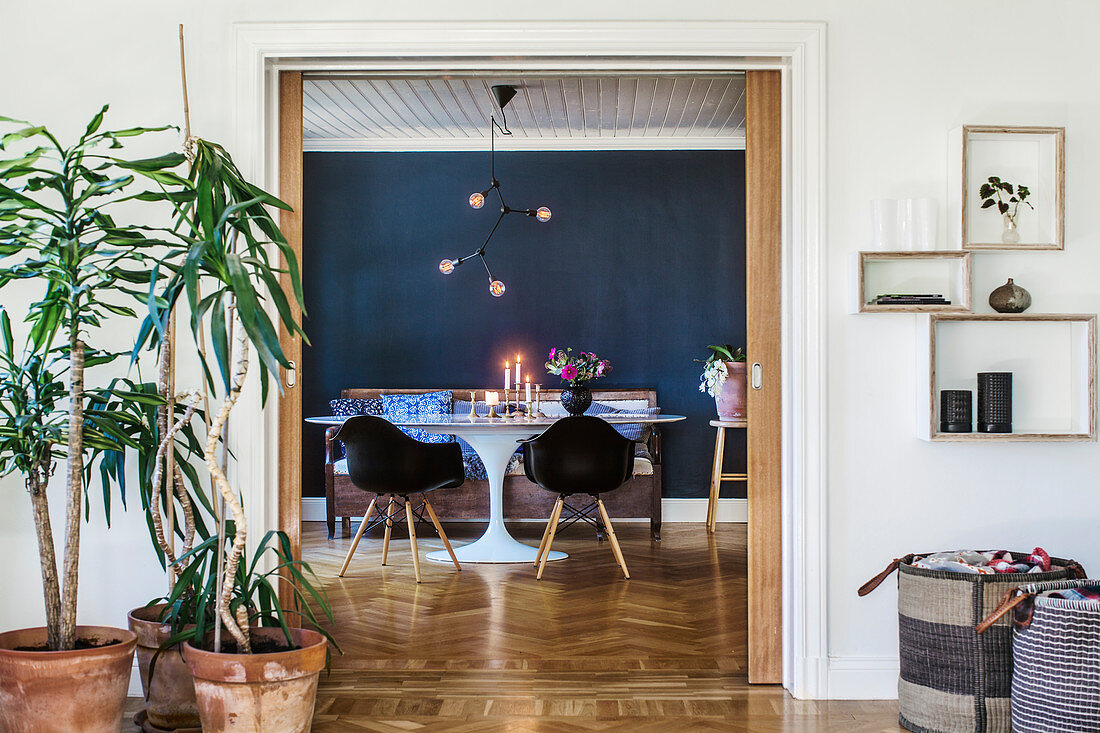 View through open sliding door in dining room with dark wall and classic furniture