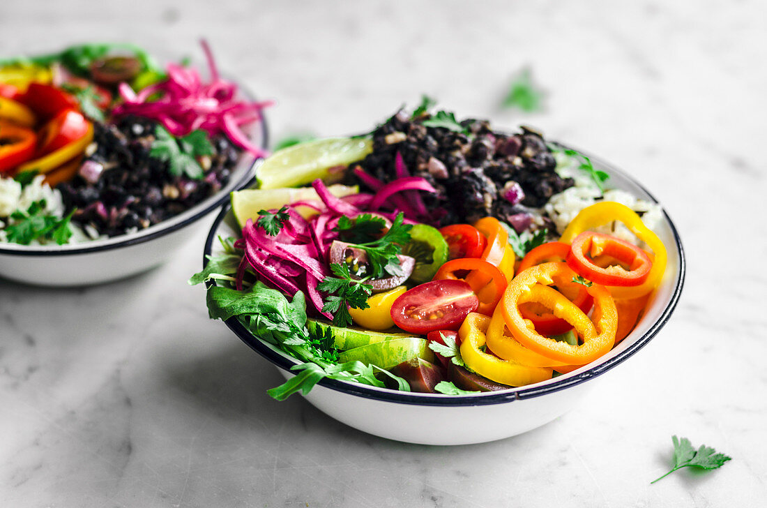 Vegane Burrito Bowls mit schwarzen Bohnen, Reis, Sommergemüse und Zwiebeln