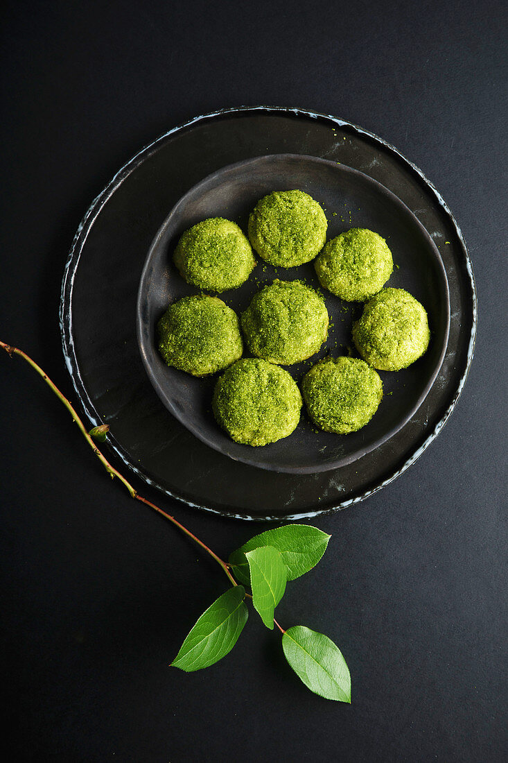 Matcha-Snickerdoodles auf schwarzem Teller und schwarzem Untergrund (Aufsicht)