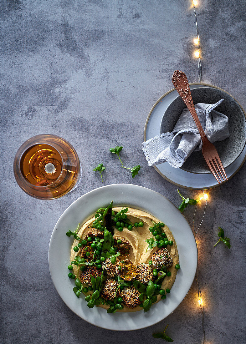 Falafel, Erbsen und verkohlte Zuckerschoten auf Hummus (weihnachtlich)