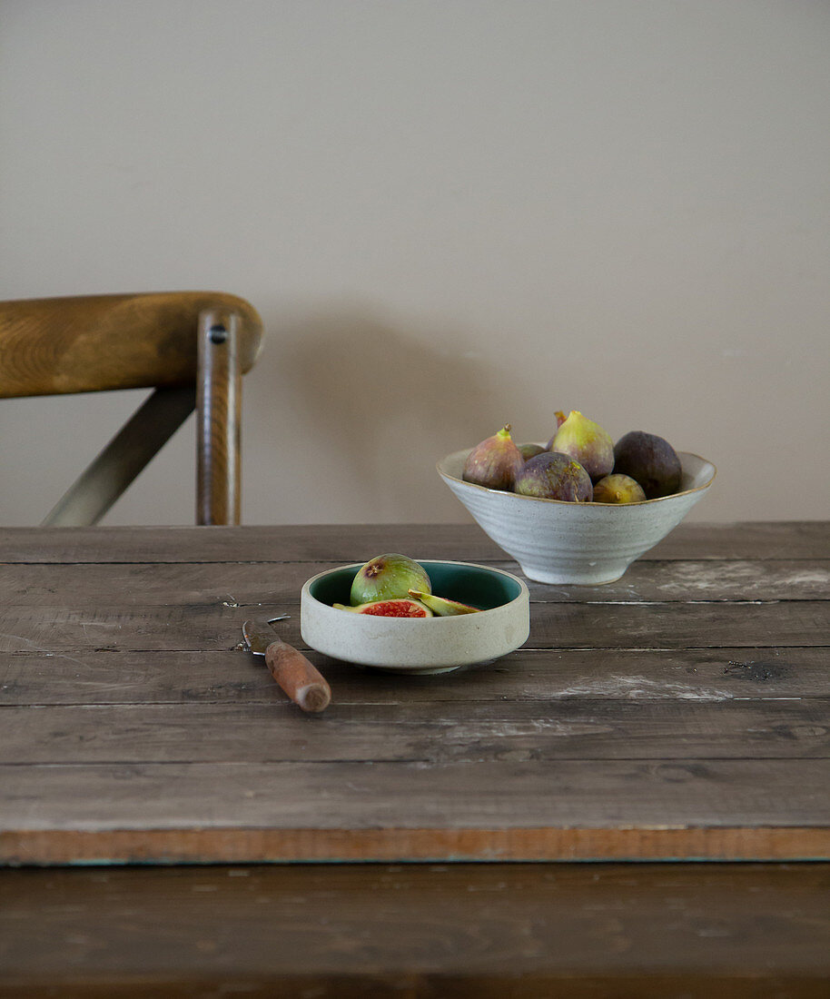 Fresh figs in bowls on a wooden table