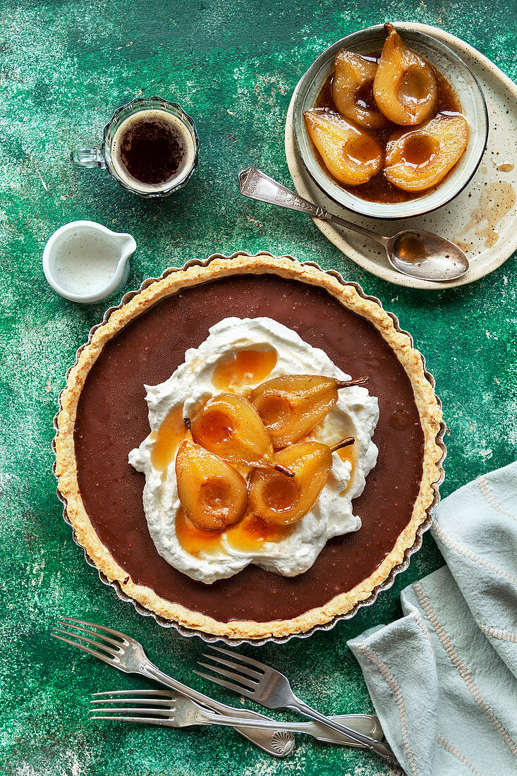 Chocolate tart topped with whipped cream and roasted pears