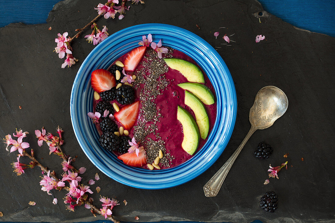 Beet and chia seeds pudding served with berries, avocado and pine nuts