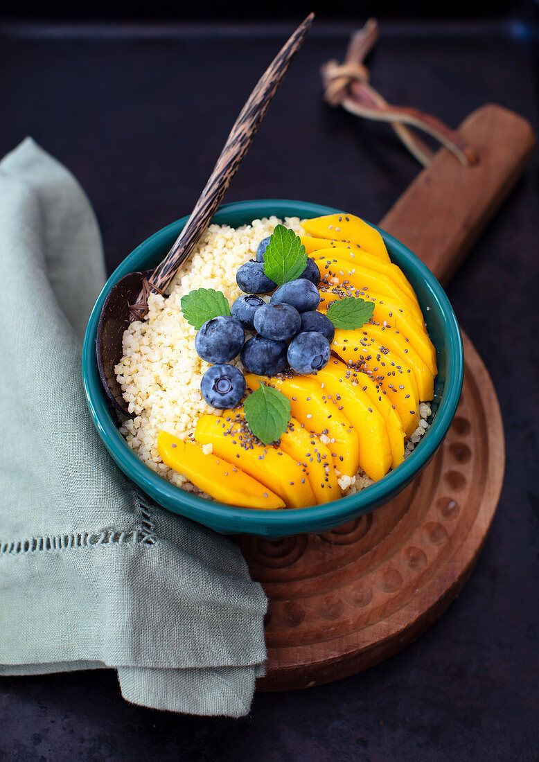Millet breakfast with fresh mango and bluberries