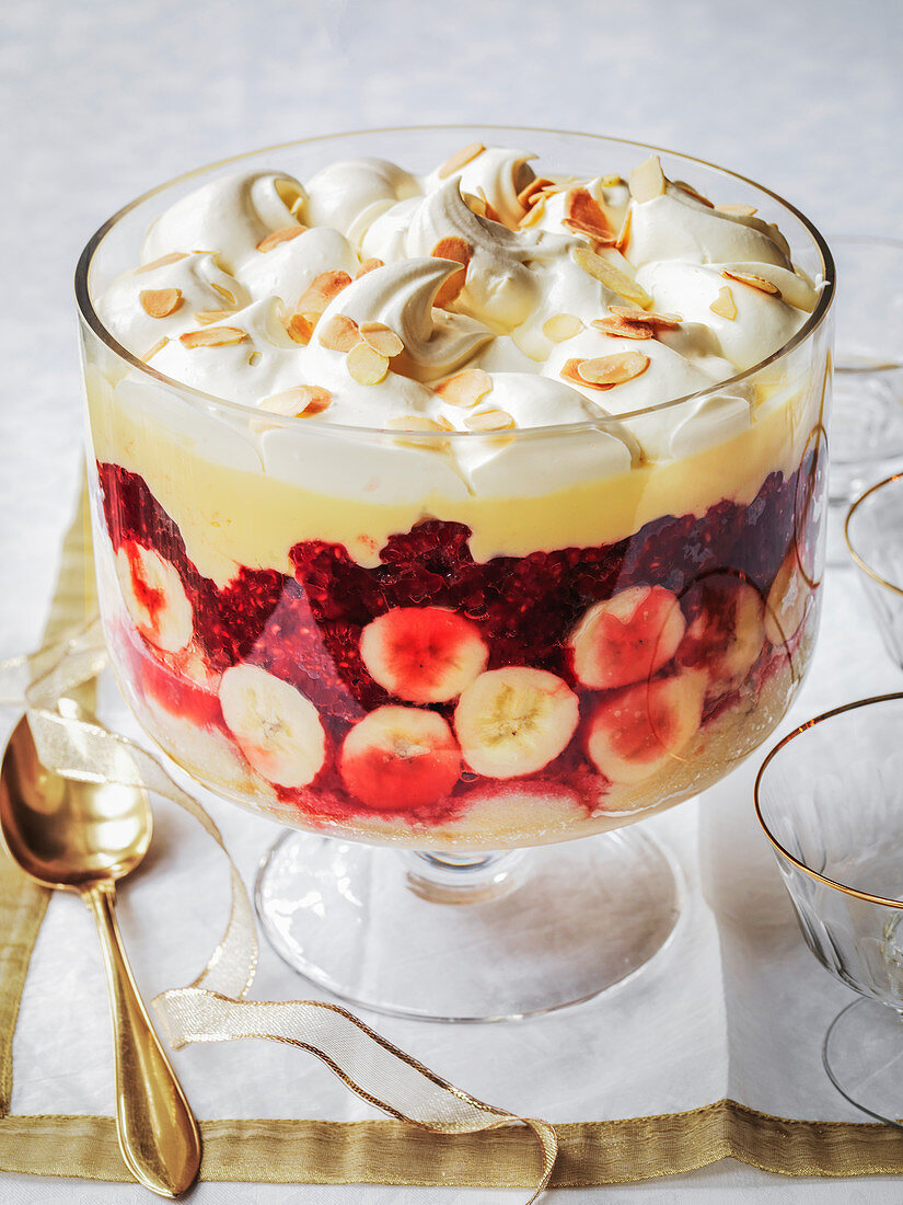 Christmas Trifle with raspberries and banana, whipped cream and custard with toasted almonds