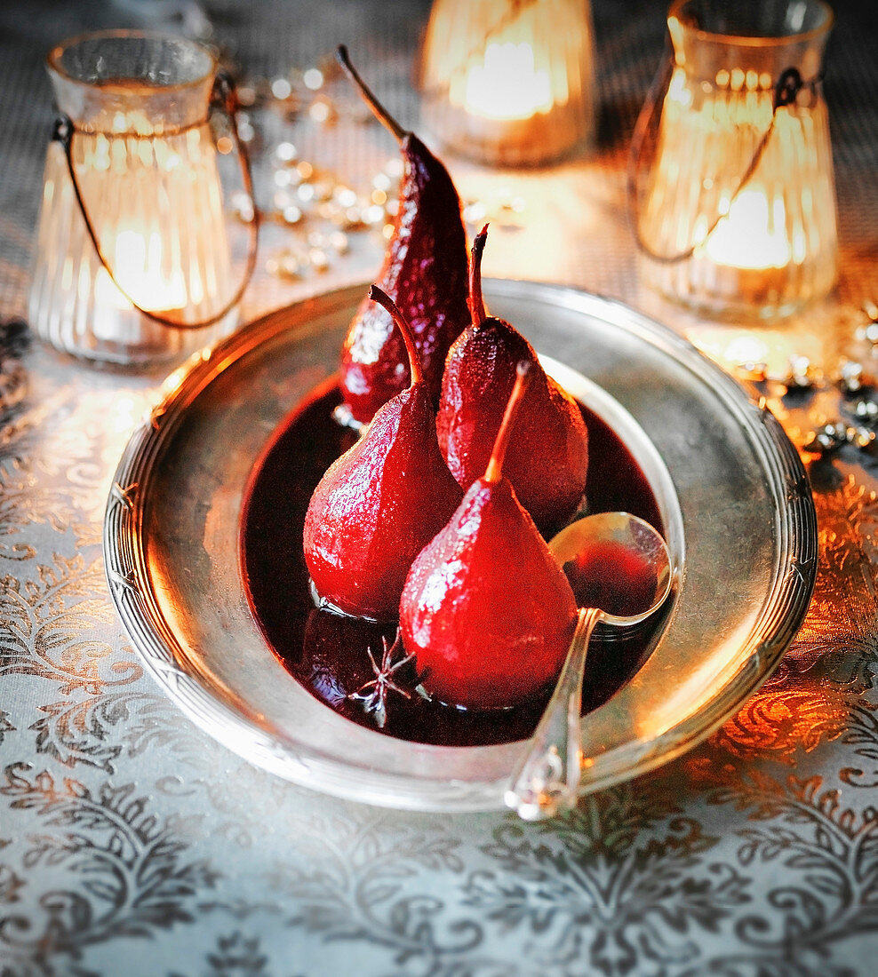 Pochierte Rotweinbirnen als weihnachtliches Dessert auf Silberplatte