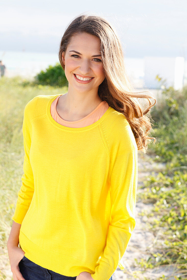 A brunette woman wearing a yellow jumper