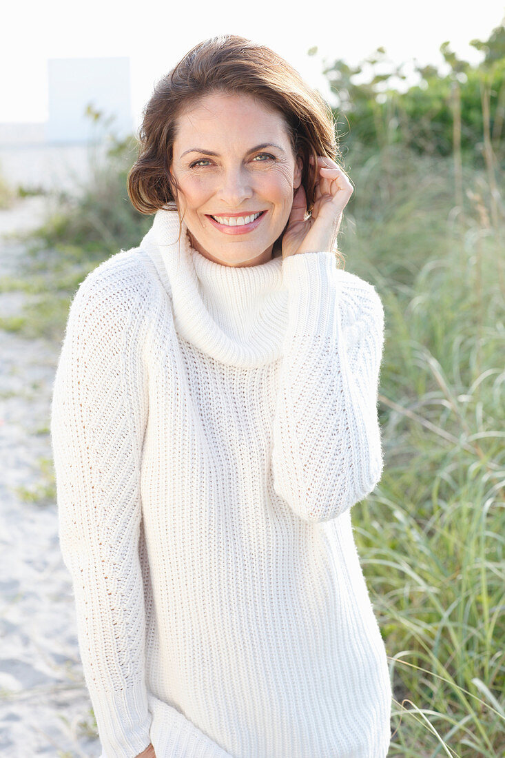 Brunette woman wearing white knit sweater