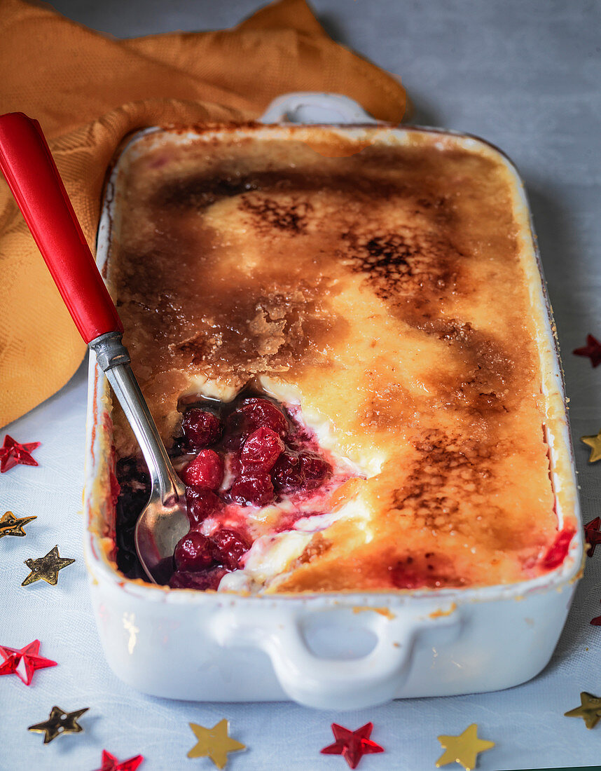 Crème brûlée mit Cranberries in Auflaufform als Weihnachtsdessert
