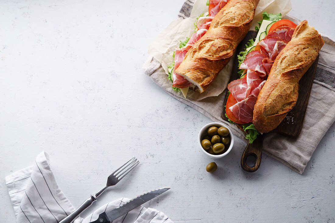 Banh Mi (Baguettesandwich) mit Schinken, Käse, Tomaten, Kopfsalat und Oliven