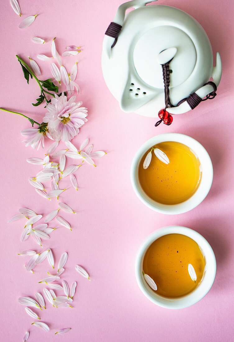 Teeschalen, Teekanne und Blütenblätter