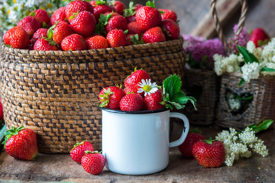 Erdbeeren im Emaillebecher und Korb