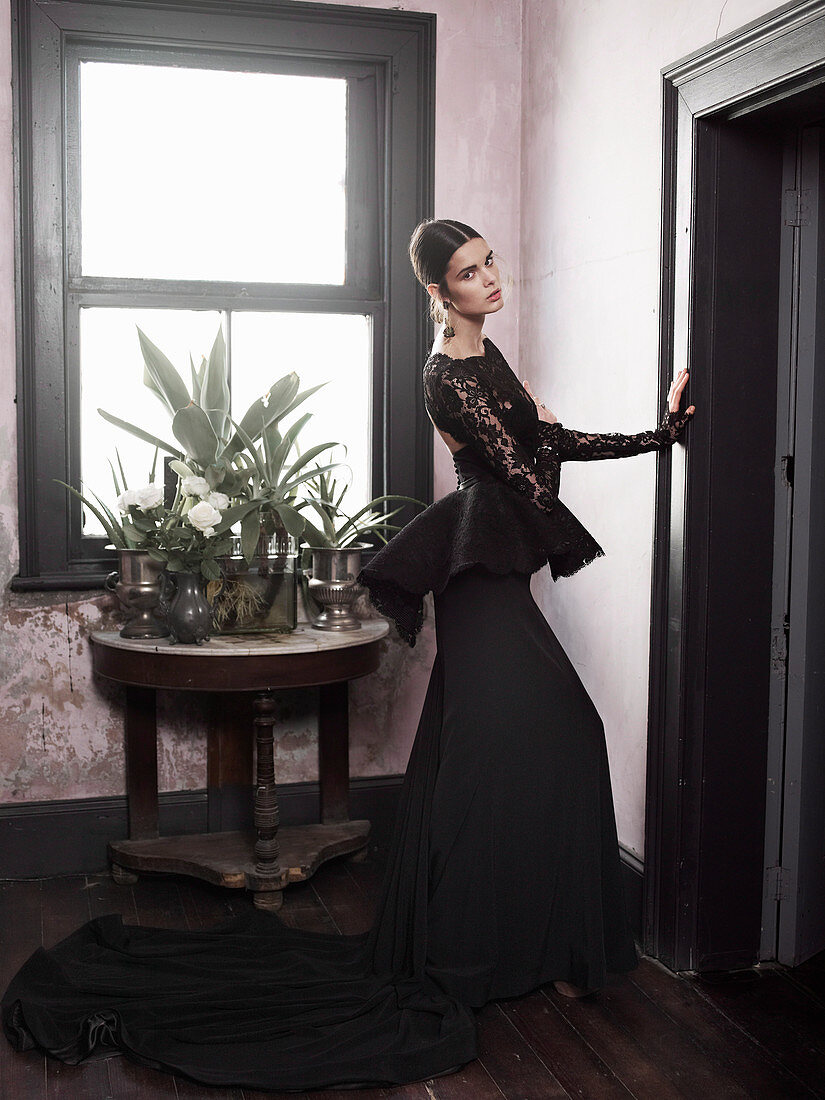 A young brunette woman wearing a Spanish evening dress in a home setting