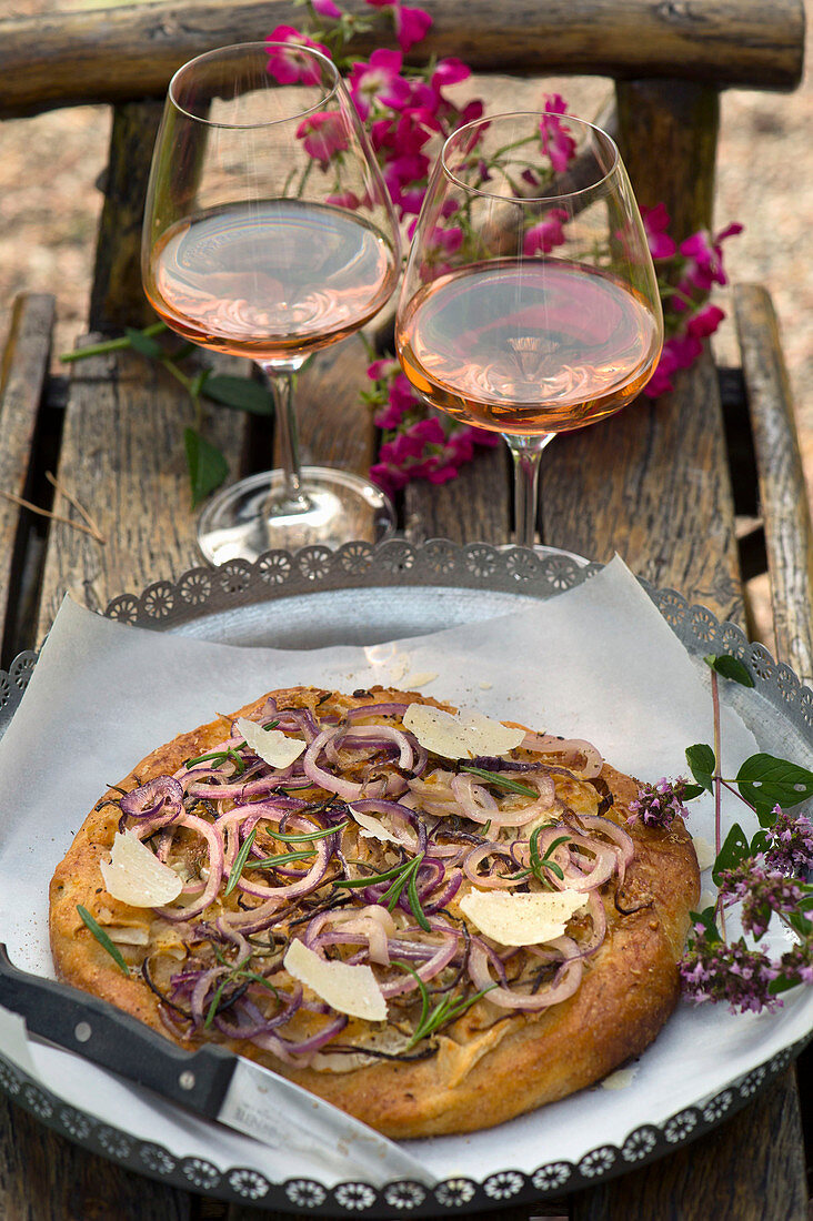 Focaccia mit dreierlei Käse, Zwiebeln und Rosmarin auf Tisch im Freien