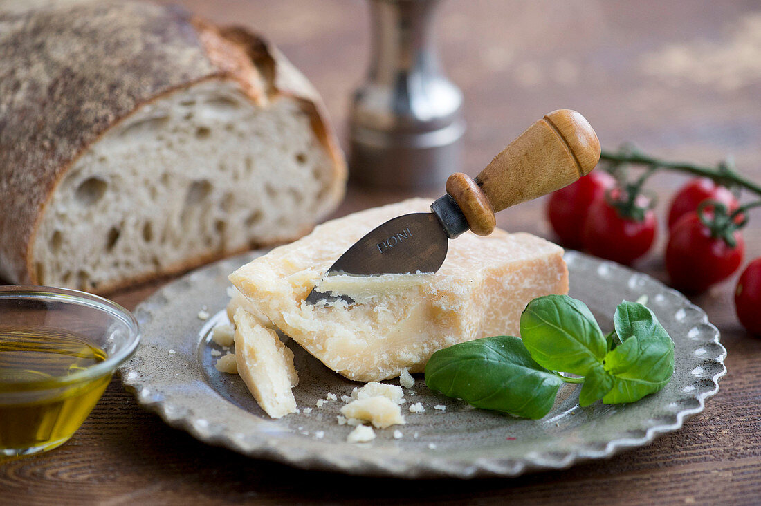 Italienisches Stillleben mit Parmesan, Basillikum, Brot, Olivenöl und Tomaten