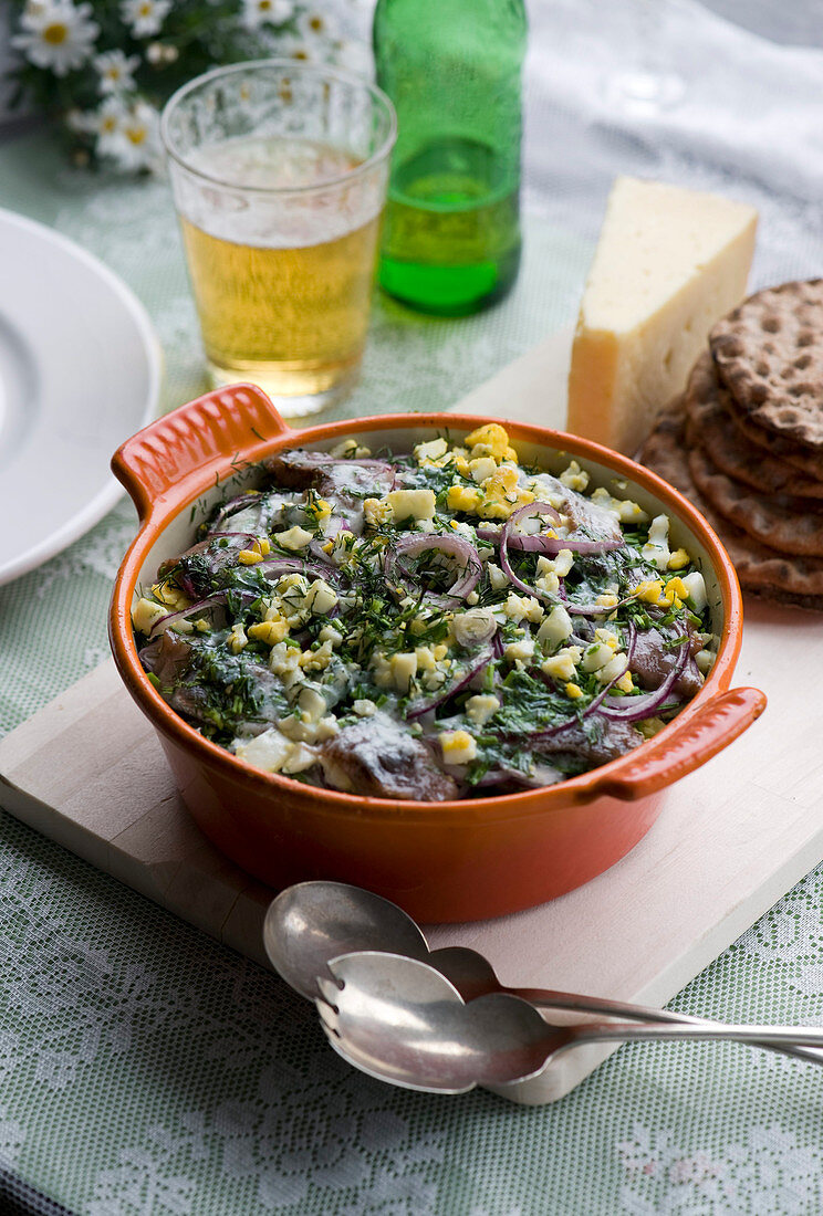 Soused herring with egg, red onions, dill and cheese in a baking dish (Scandinavia)