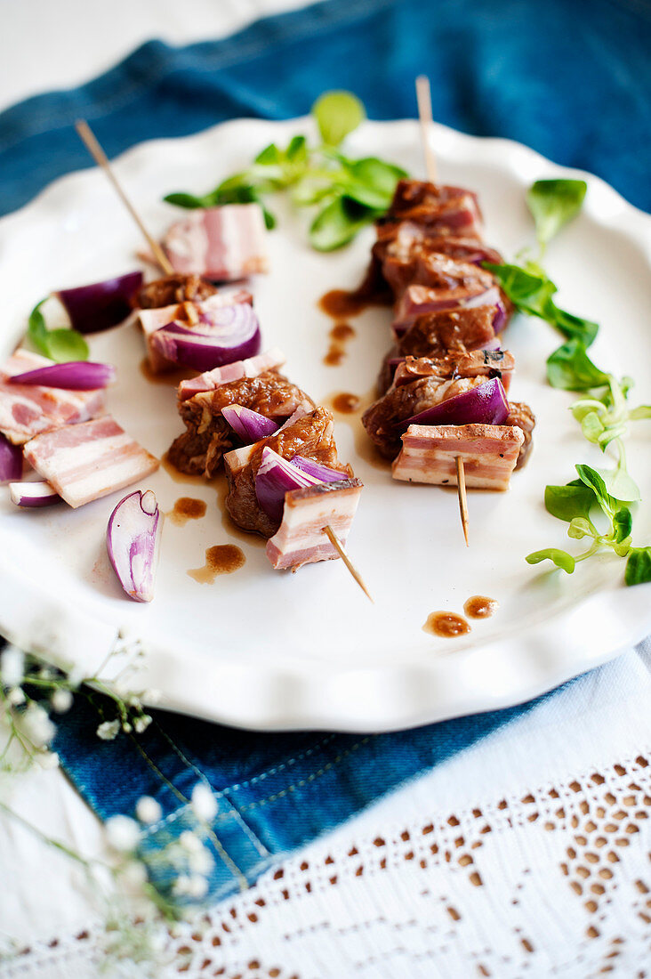 Pork skewers with bacon and red onions