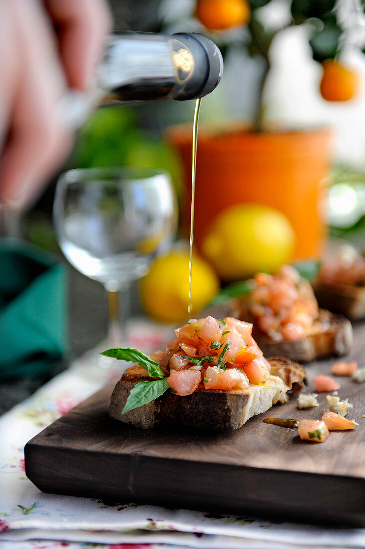 Olive oil being drizzled over tomato bruschetta (made by Stefano Catenacci, Sweden)