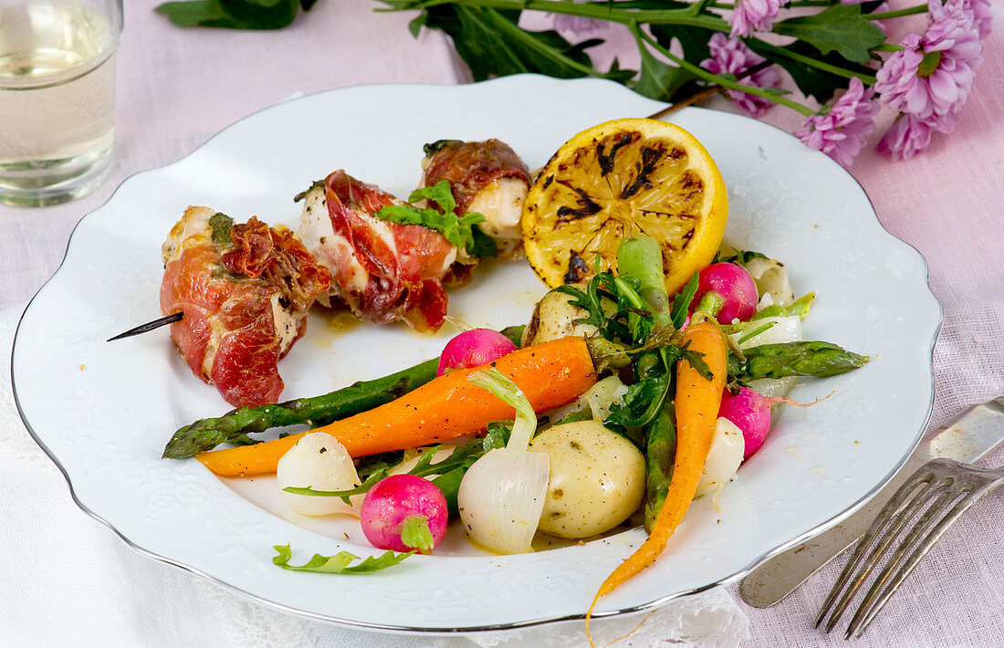 Chicken skewers wrapped in a Parma ham with a warm vegetable salad
