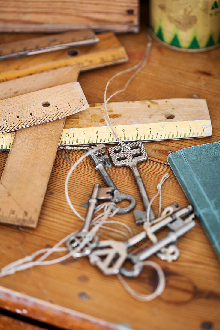 Verschiedene Holzlineale und Vintage Schlüsssel auf Tisch