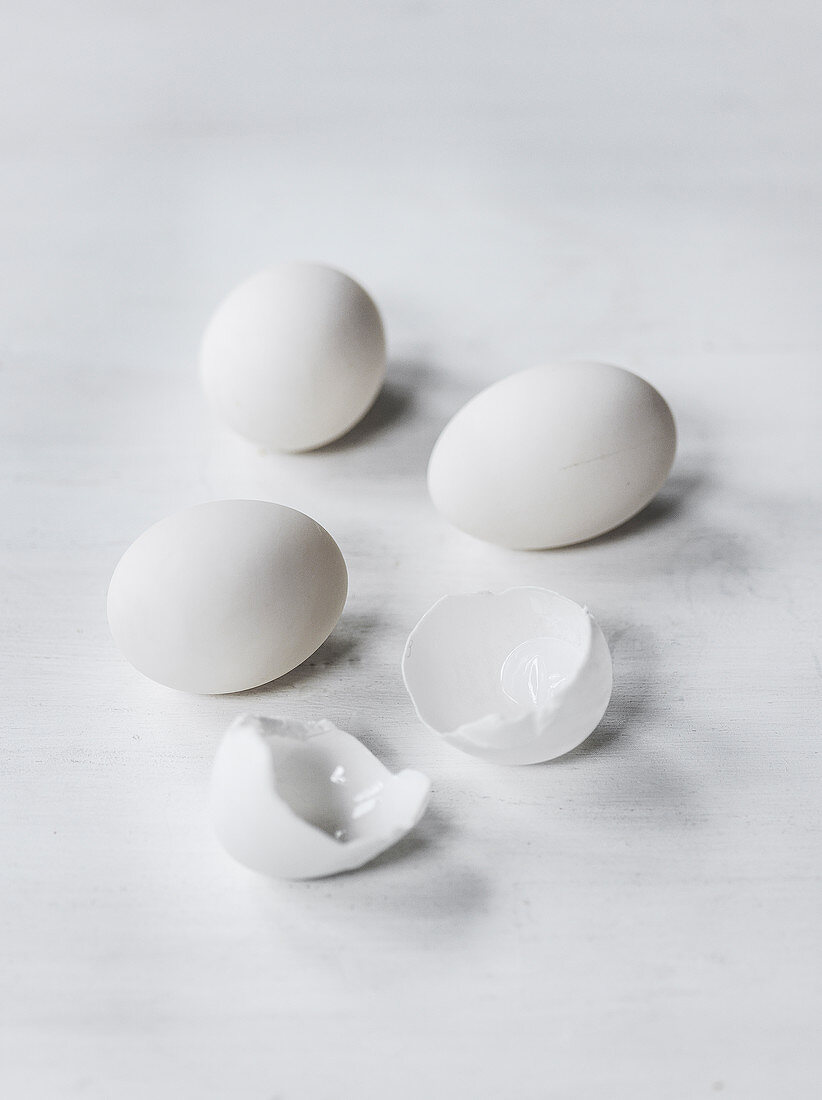 Drei weiße Eier und Eierschalen