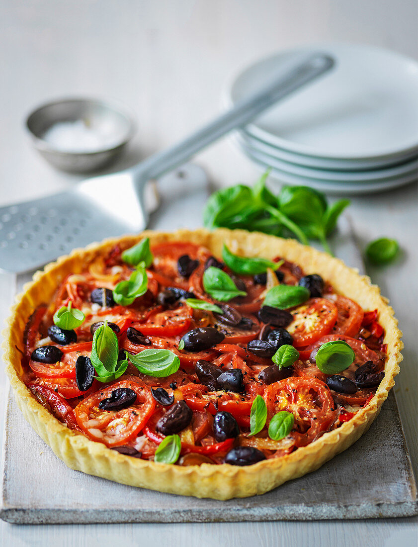 Olive and tomato tart served with basil