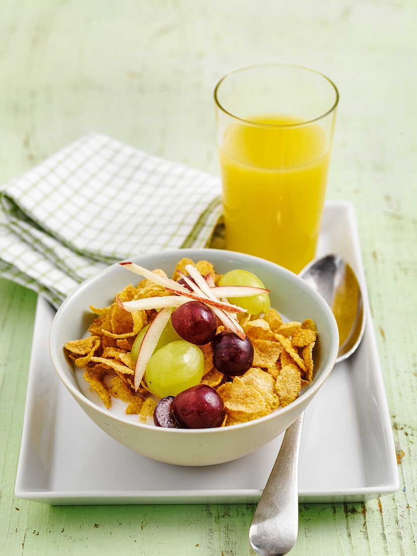 Cornflakes, grapes and shredded apple with orange juice