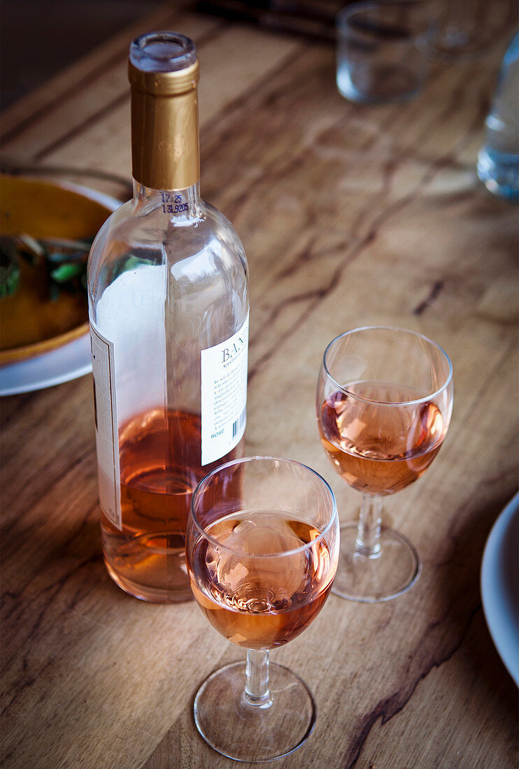 Provenzalischer Rosewein in Flasche und Gläsern auf Holztisch