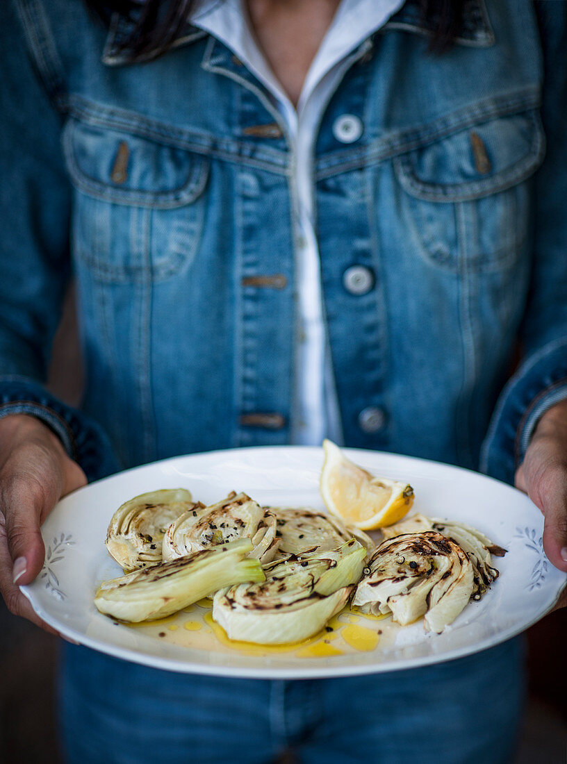 Grilled Fennel with lemon juice and olive oil held in the hand