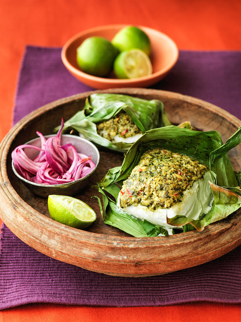 Indian spiced fish wrapped in banana leafs with red onion