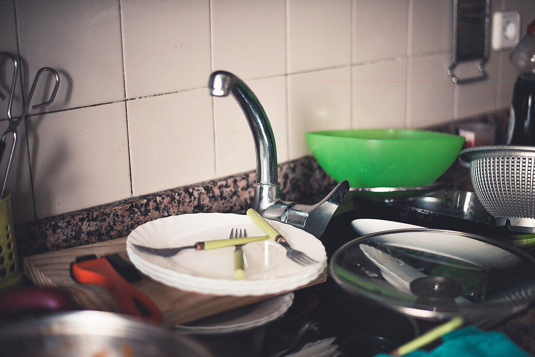Schmutziges Geschirr im Spülbecken und auf der Arbeitsfläche in der Küche