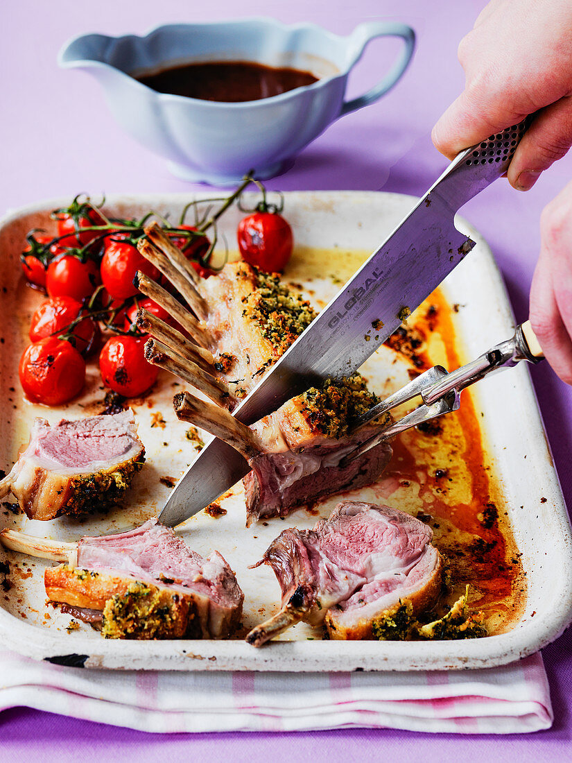 Carving easter rack of lamb with roast tomatoes and gravy