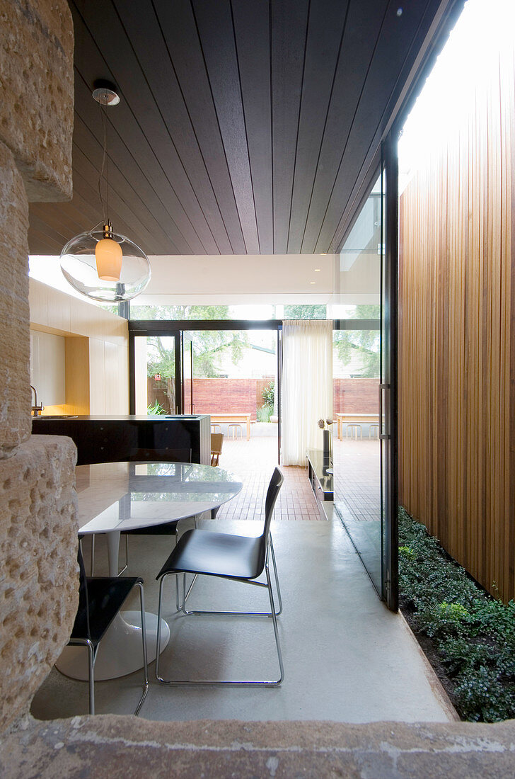 View into open-plan interior with sliding door opening onto light well