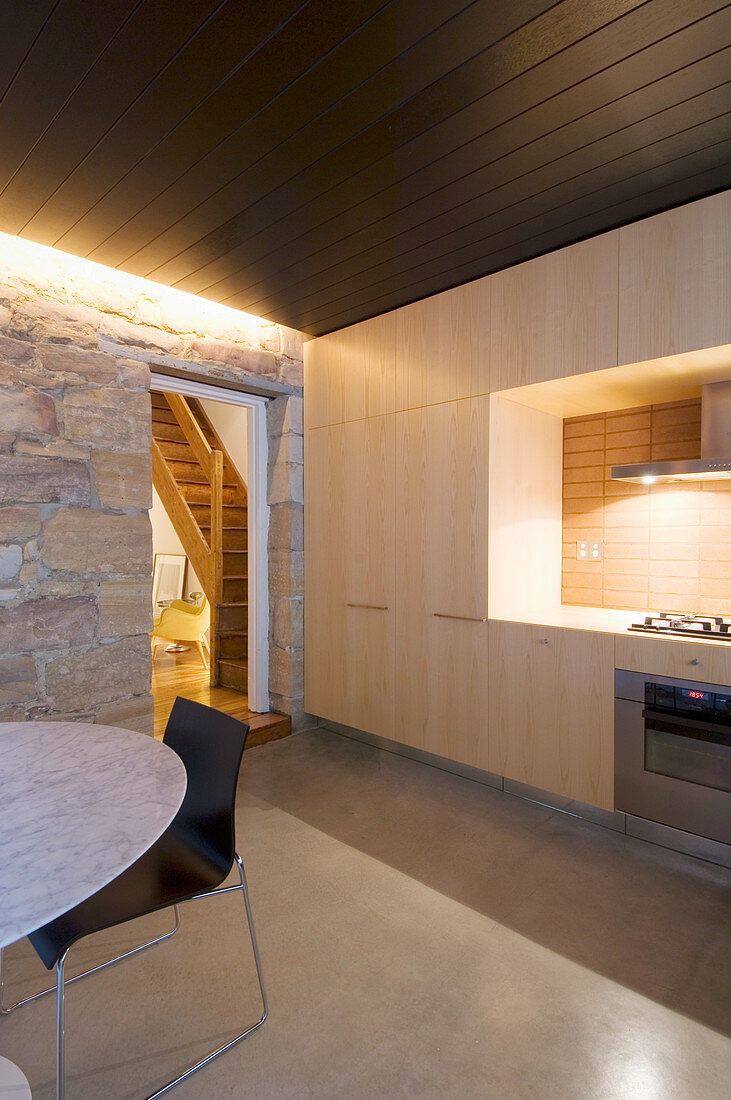 Moderne Einbauküche aus hellem Holz und dunkle Holzdecke