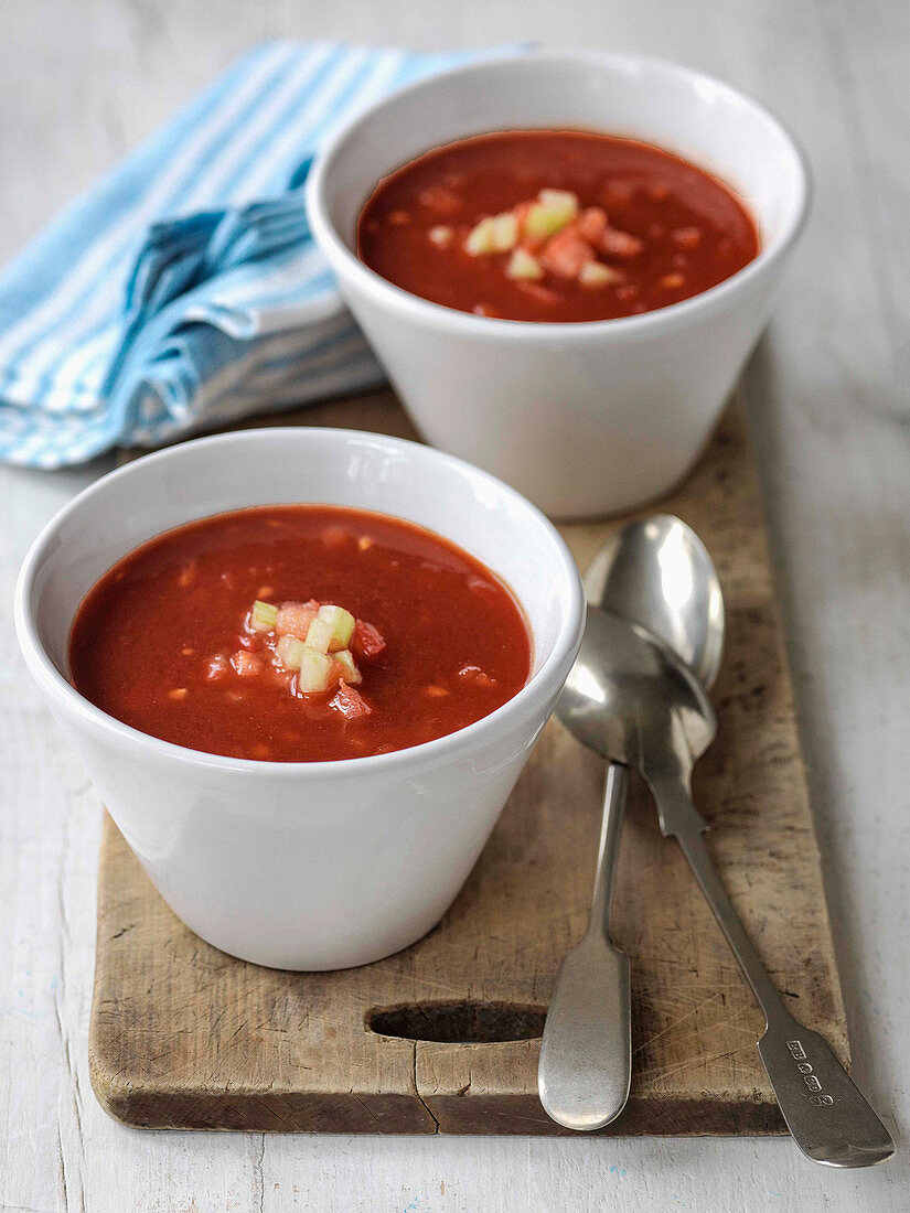 Bloody Mary Soup in two bowlsg rnished with chopped tomatoes
