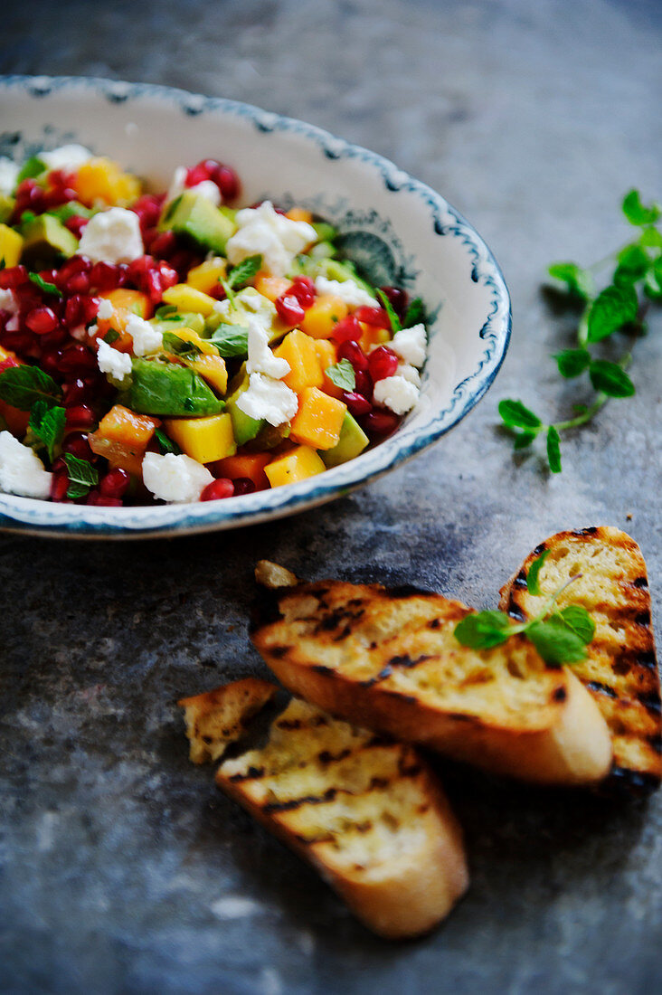 Salsa with feta cheese, pomegranate seeds and grilled bread